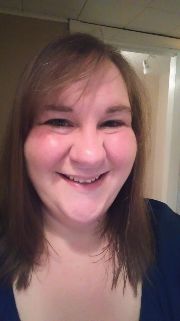 A woman smiling for the camera with her mouth open.