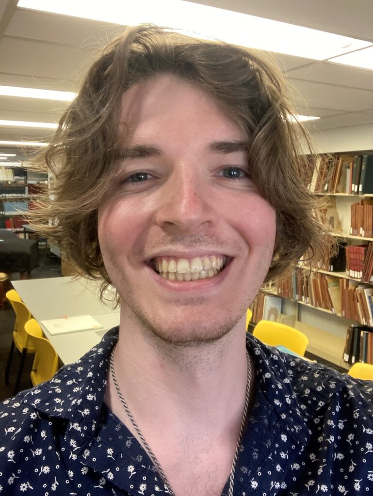 A man with long hair and a smile.