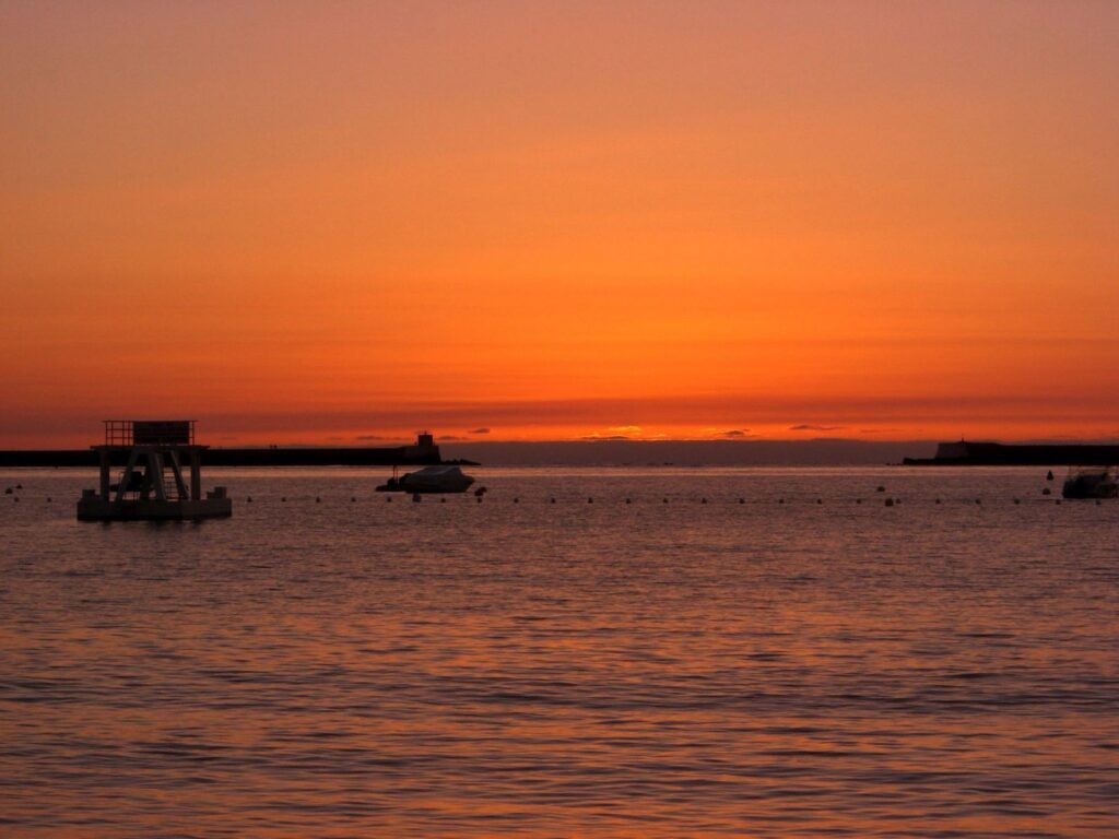 A boat is in the water at sunset.