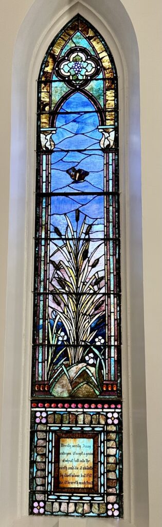 A stained glass window with a plant in the middle.