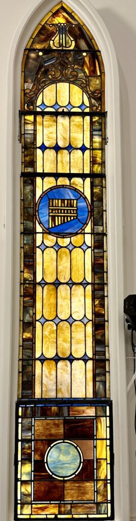 A stained glass window with a large blue and yellow design.