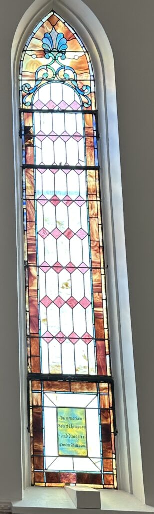 A stained glass window with pink and red squares.