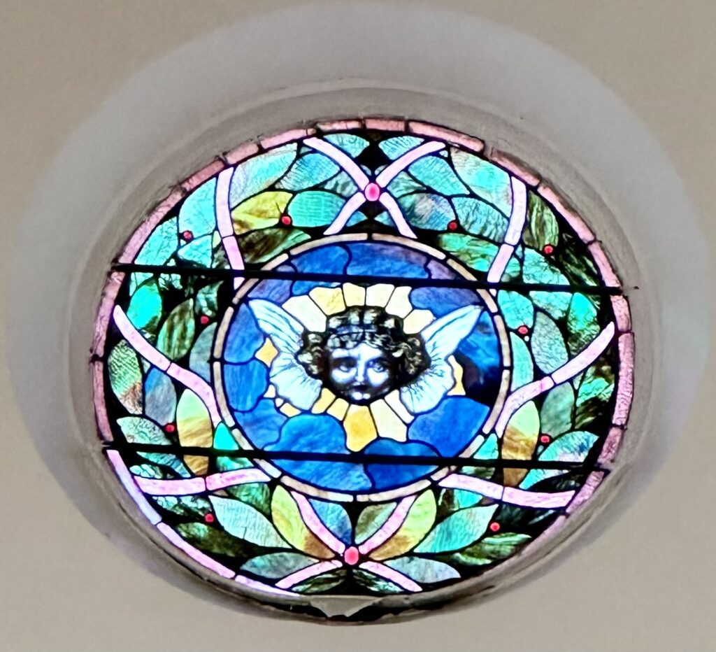 A stained glass window with a cat in the center.