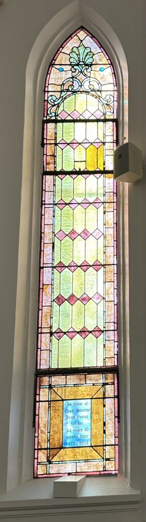 Arched stained-glass church window with floral motif