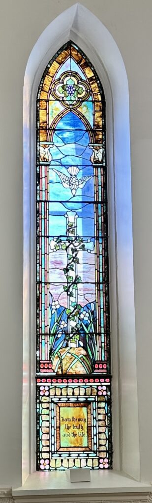 A stained glass window with a cross on it.