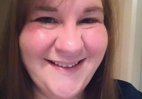 A woman smiling for the camera with her mouth open.