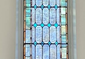 A stained glass window with blue and green designs.