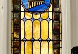 A stained glass window with a large blue and yellow design.
