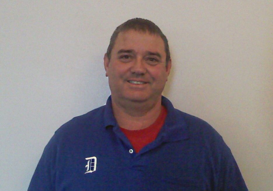 A man in blue shirt smiling for the camera.