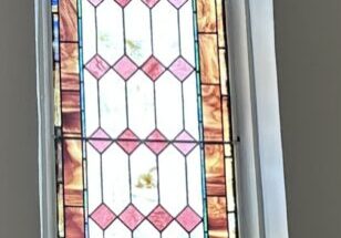 A stained glass window with pink and red squares.