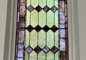 Narrow arched stained-glass window with sky panel