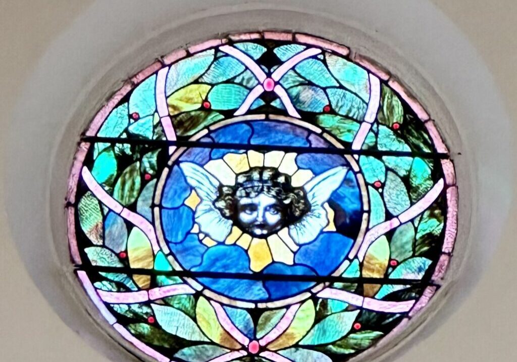 A stained glass window with a cat in the center.
