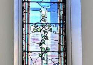 A stained glass window with a cross on it.